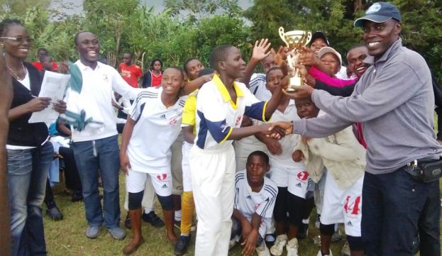 The Sports teacher of Kyebambe Girls School Mr. Mutwamu Paul hands over the winner&#039;s trophy to Kilembe SSS.